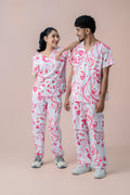Female and male healthcare professionals wearing pink heart print medical scrub sets