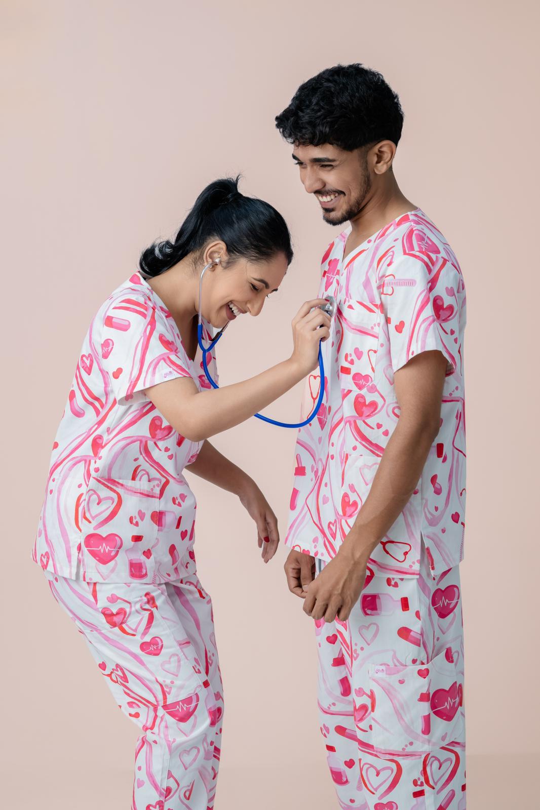 Male and female healthcare professionals wearing pink heart print scrub tops