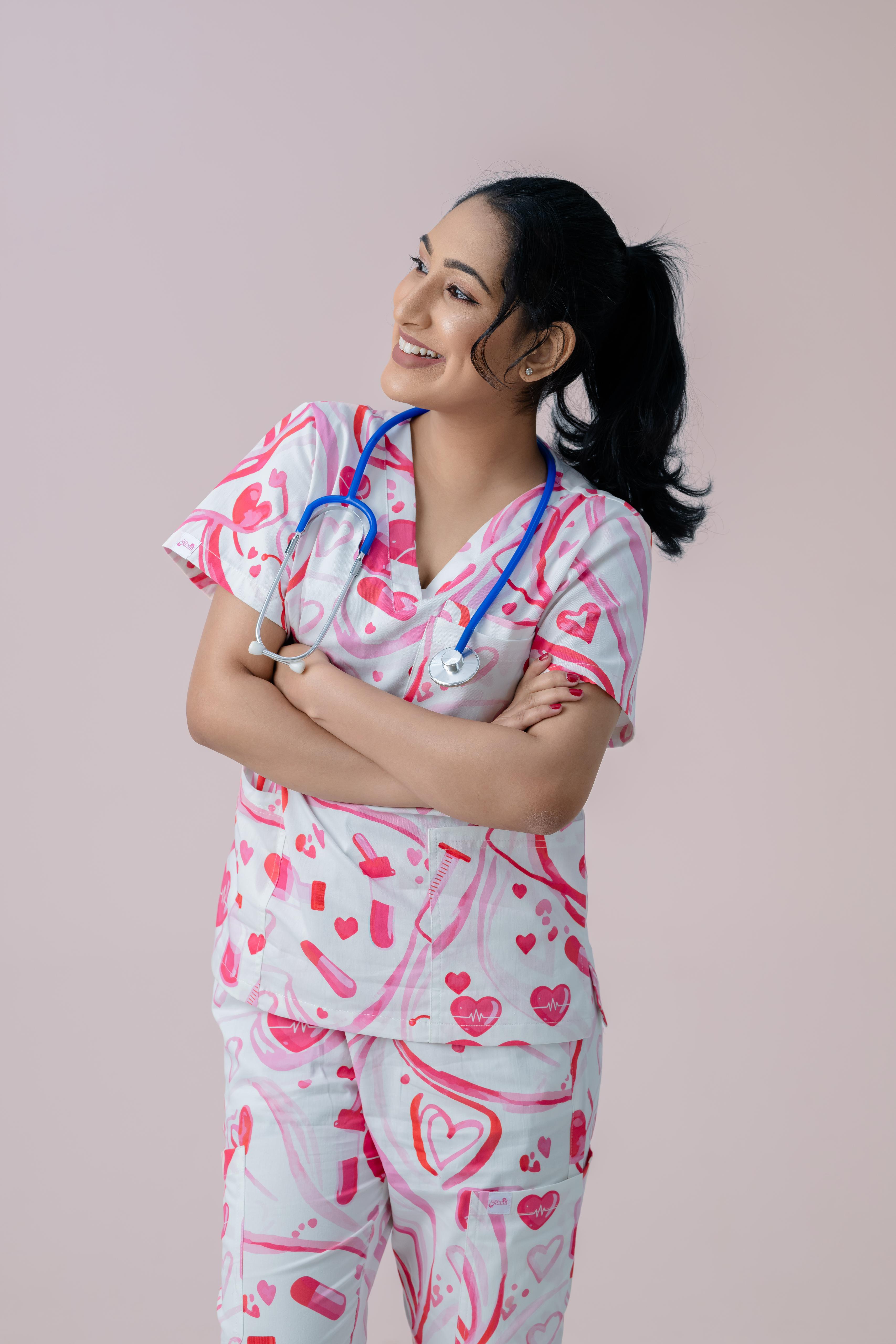Female nurse wearing pink heart print V-neck scrub top and scrub pants