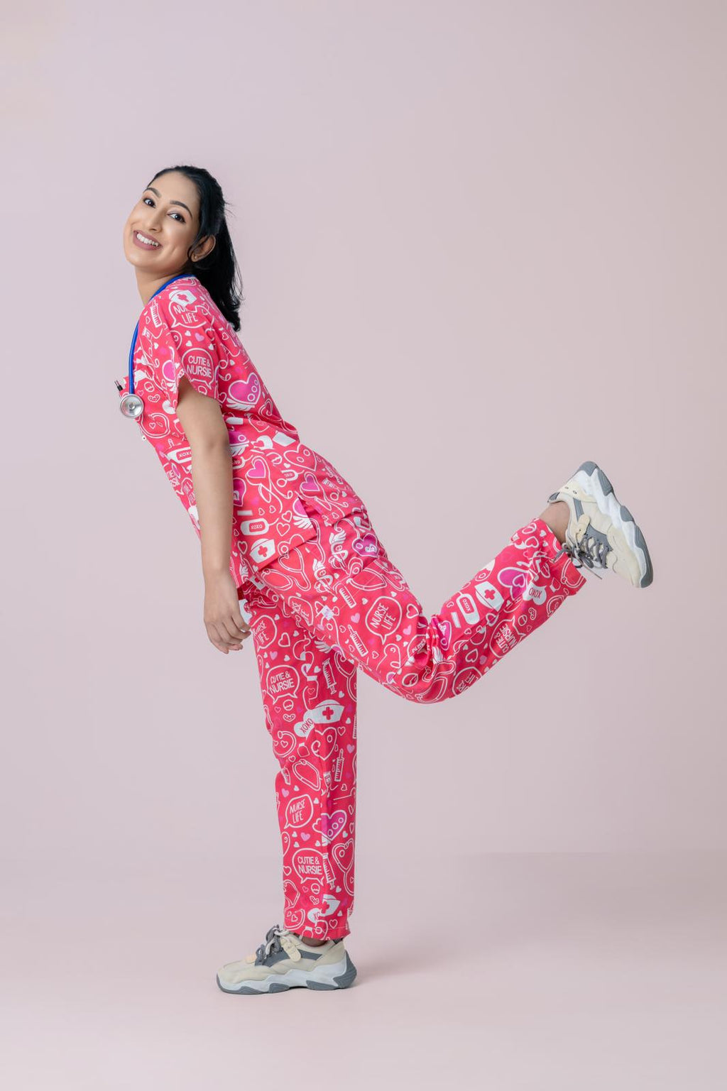 Healthcare worker in pink heart print scrub top and jogger scrub pants