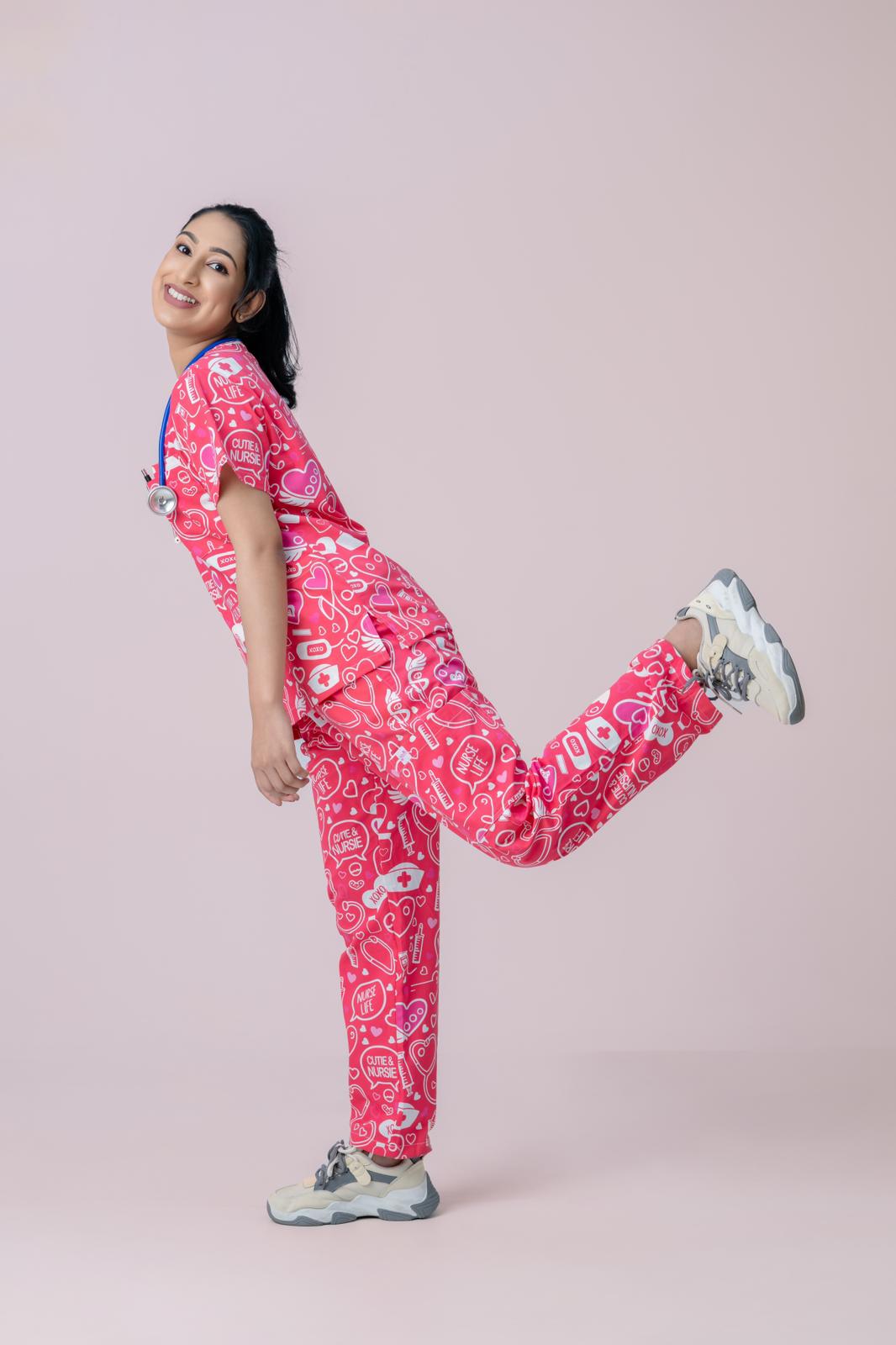 Healthcare worker in pink heart print scrub top and jogger scrub pants