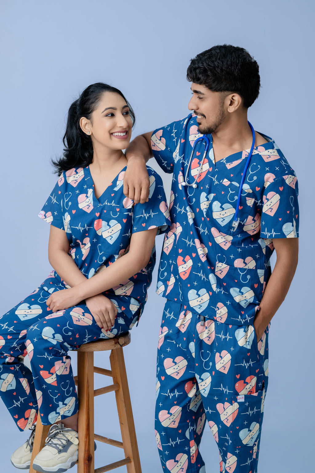 Male and female medical professionals wearing matching navy blue scrub sets